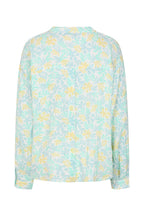 Light blue blouse with yellow floral pattern on a white background