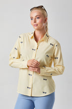 Buy Online Bella Shirt Alice Collins - Woman wearing a light yellow shirt with small dark patterns on a plain background
