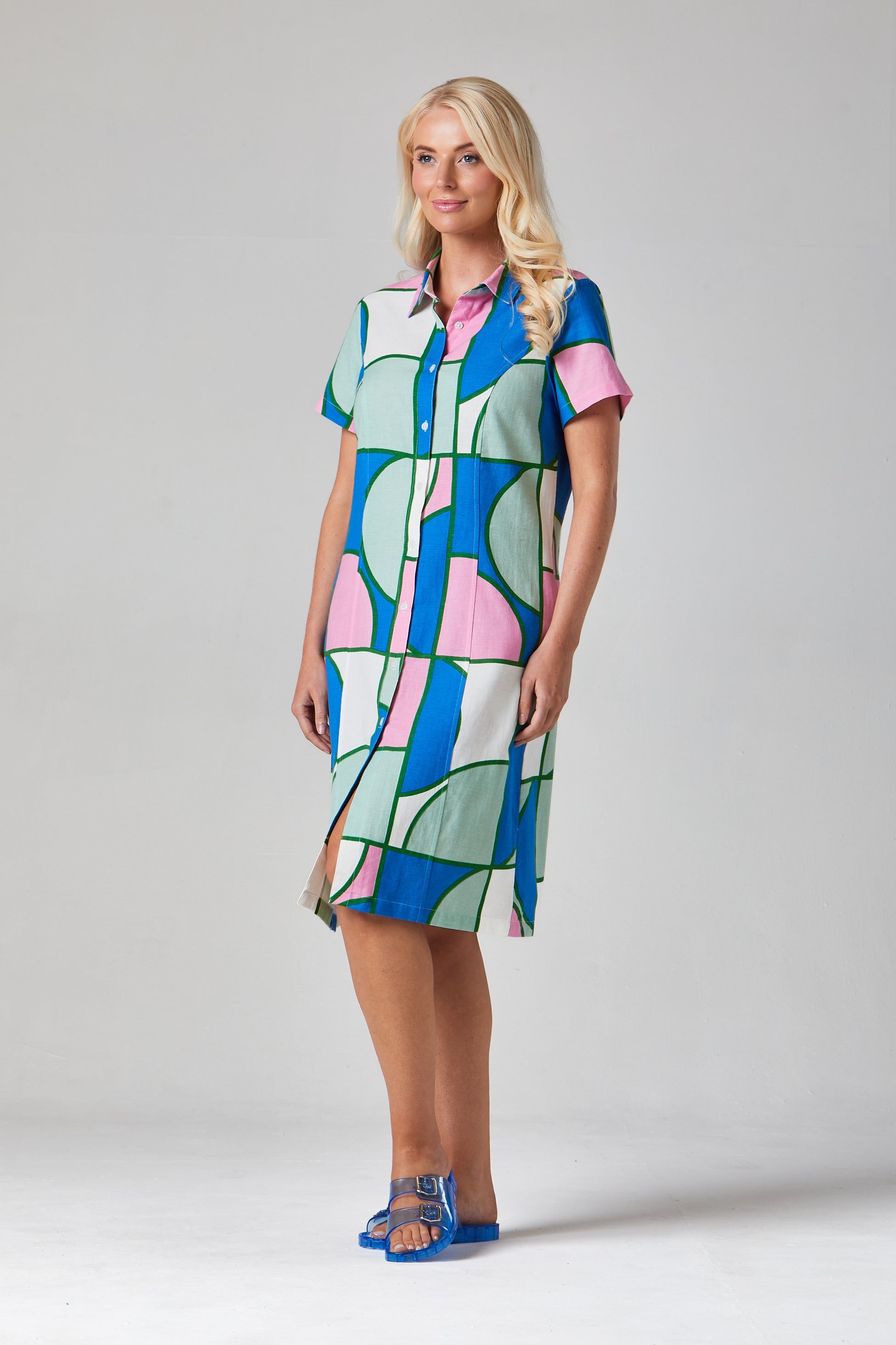 Buy Rosa Shirt Dress Online Alice Collins - Woman wearing a colorful patterned dress on a plain background