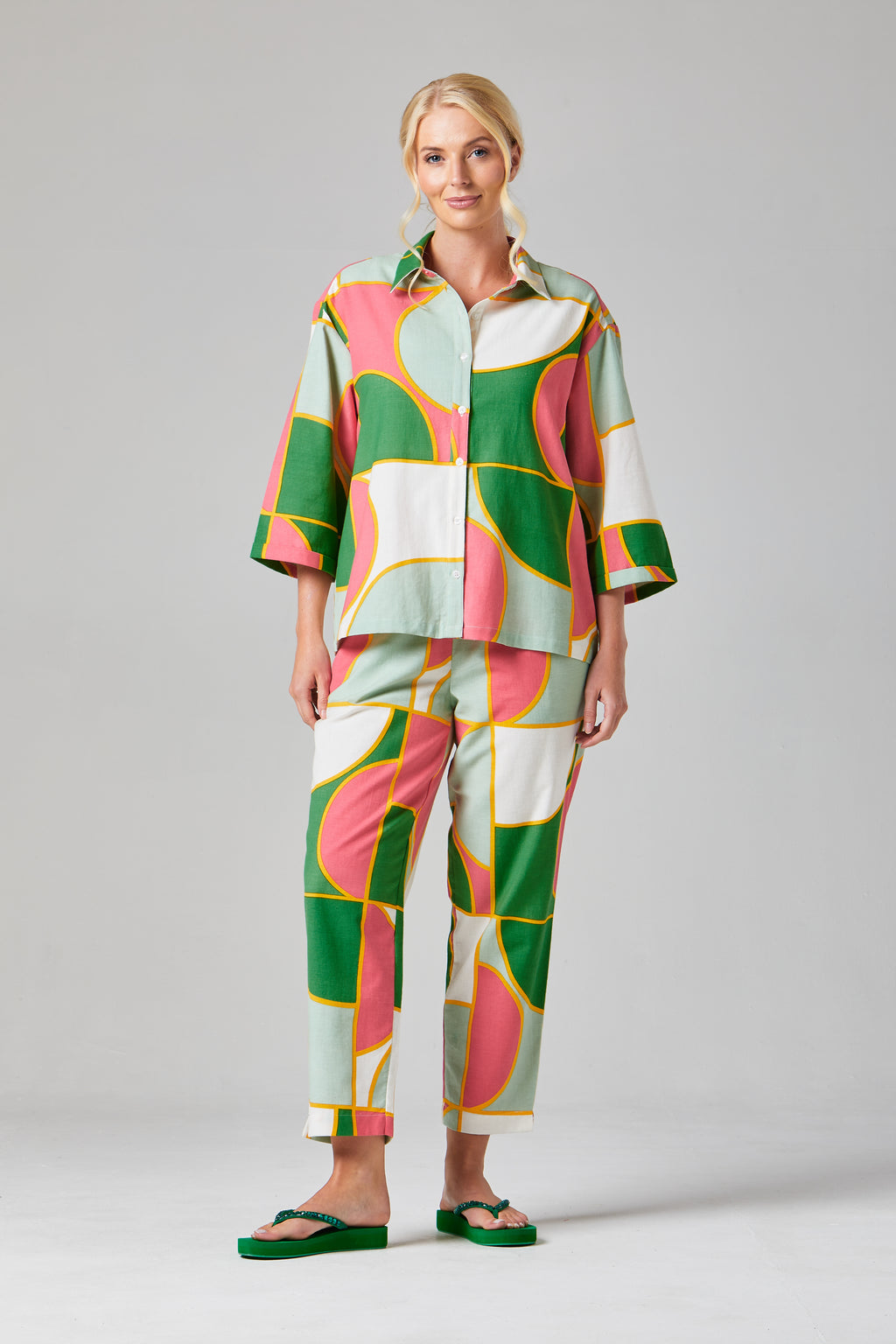 Buy Rosa Crop Trousers Online Alice Collins - Woman wearing a colorful patterned outfit on a gray background