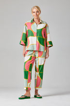 Buy Rosa Crop Trousers Online Alice Collins - Woman wearing a colorful patterned outfit on a gray background