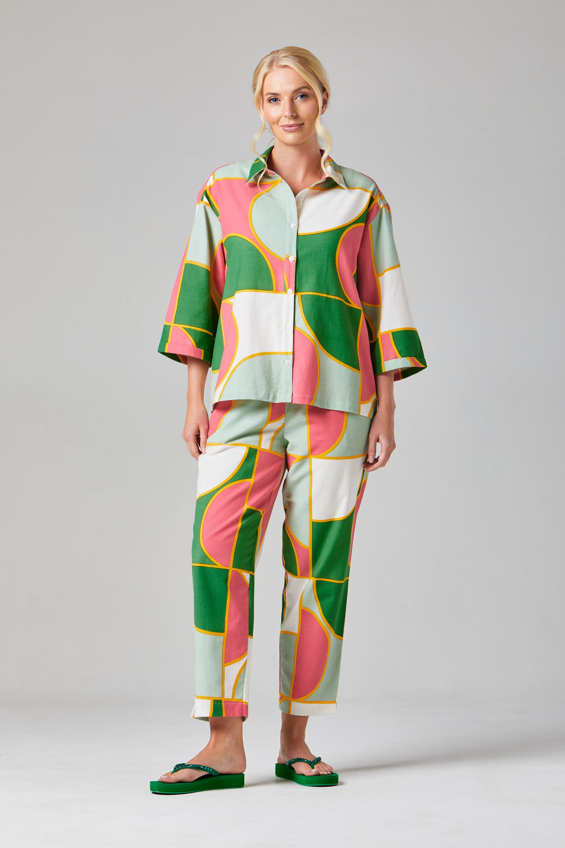 Buy Rosa Crop Trousers Online Alice Collins - Woman wearing a colorful patterned outfit on a gray background