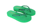 Green flip-flops with rhinestone straps on a white background